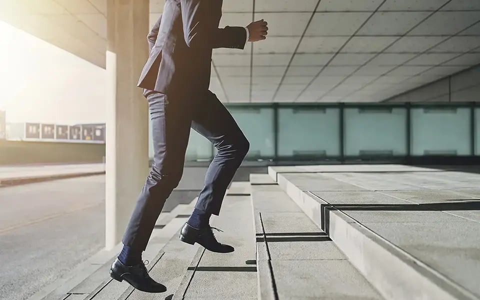 Man in a suit runs up the stairs