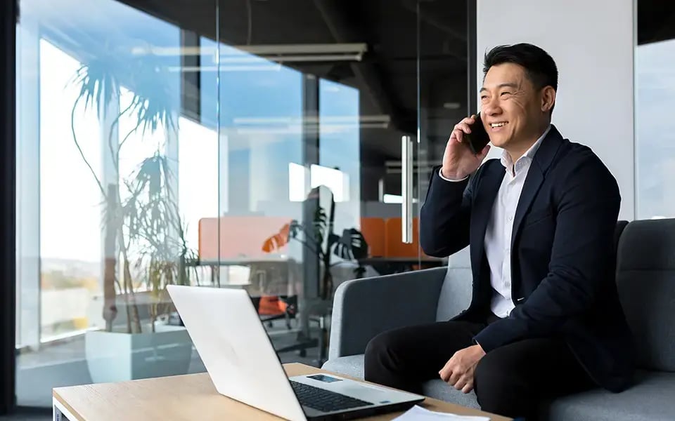 中国商人在笔记本电脑前打电话